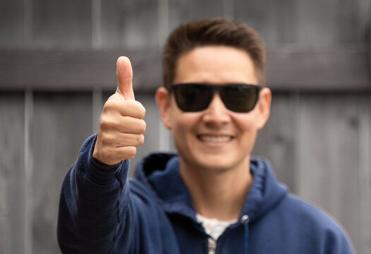 Happy young man making thumbs up gesture 