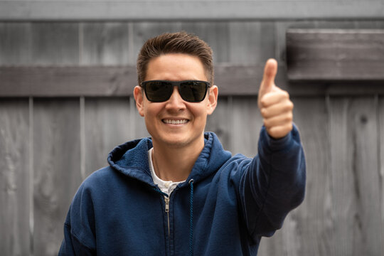 Happy young man making thumbs up gesture 