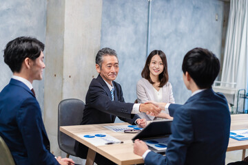 笑顔で握手をするビジネスパーソン