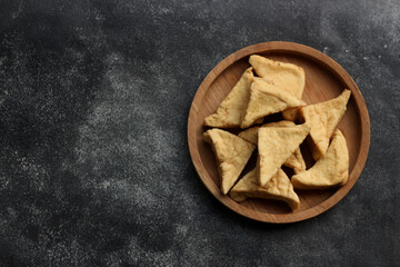 Brown Tofu or Fried Tofu on wooden Plate. Isolated on Black Background. 