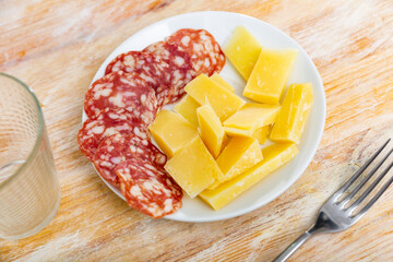 Fresh sliced meats and cheese served on plate on table. Platter of lunch meats.