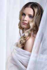 Portrait of a young woman against a background of white fabric. Female beauty concept. - 775509787