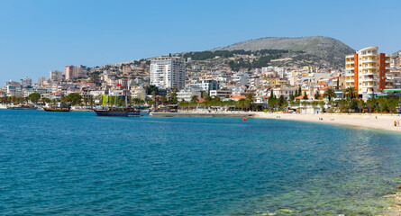Scenic view of modern cityscape of Sarande on shore of open blue bay of Ionian Sea on sunny spring...