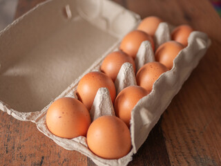 Fresh Brown Eggs in Carton on Wooden Table