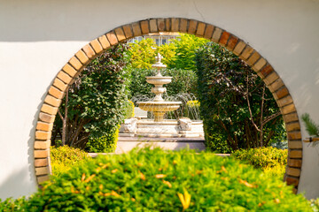 Japanese garden. A round garden arch in a decorative wall.