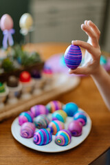 Hand holding a purple and pink Easter Egg - Easter traditions