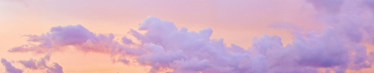 Aesthetic Pastel Sunset, violet fluffy clouds on pink peach colored sky, dreamy cloudscape pastel tones, surreal dreamscape at sunset, soft colorful heaven, wide banner, panoramic view.