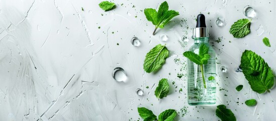 A bottle of water with mint leaves on a white surface