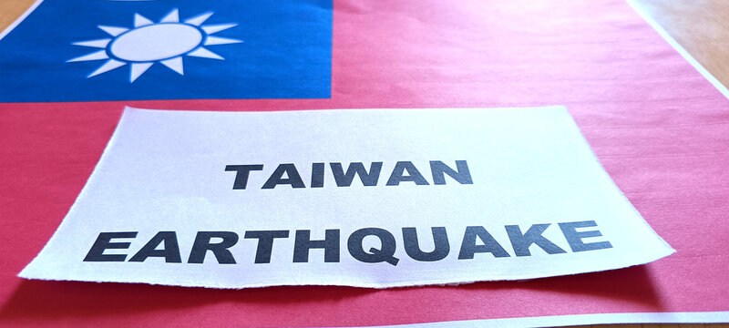 closeup image of Taiwan earthquake and their flag printed in paper on desk. 