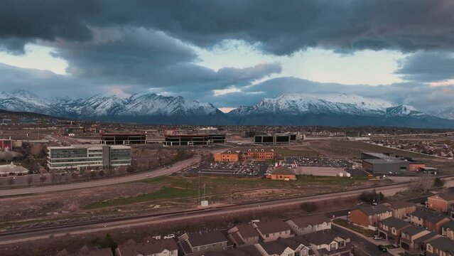 Lehi Utah and silicon slopes beneath snow-capped mountains in spring - aerial motion hyper lapse