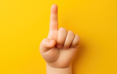 Finger pointing upward on yellow background