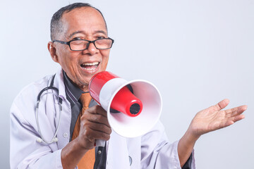 Senior Asian doctor male using megaphones announces good news and presenting empty space for ads