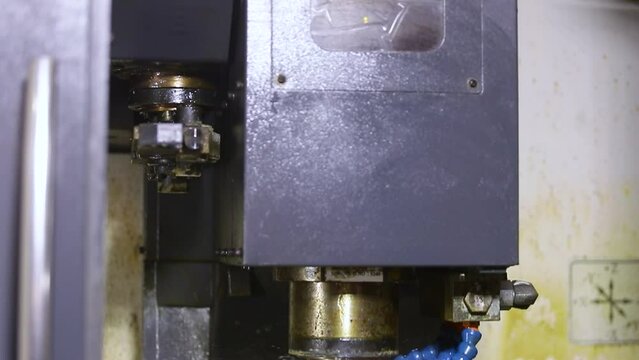 CNC vertical milling machine with face mill endmill tool in process over aluminum metal piece, Industrial Factory coolant liquid on metal component in shaping forming process