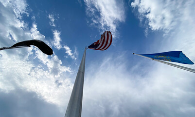 America Flag, POW Flag, and South Dakota Flag against blue sky