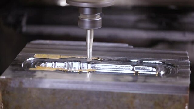 automated cnc vertical milling machine with face mill endmill tool in process over aluminum metal piece, Industrial Factory coolant liquid on metal component in shaping forming process