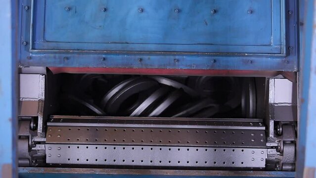 automatic shot blasting machine, for cleaning forged components, fettling process of metal parts in a large machine rotating rounds in a forging and machining foundry factory