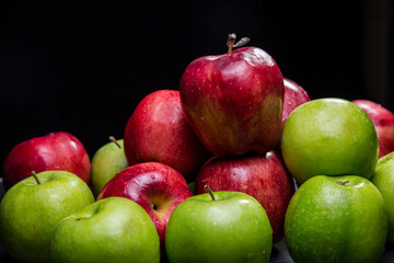 Red and green apples, black background