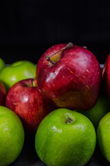 Red and green apples, black background