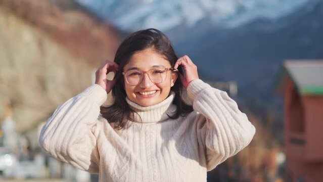 4K Portrait of a Gorgeous Indian  woman Smiling Charmingly while Standing in mountains at Keylong, Lahaul, India. Girl Wearing warm sweater. Happy Young Woman Enjoys Life. Girl smiles at camera.