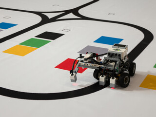 Robot with wheels is moving along the black line. Line following with a sensor