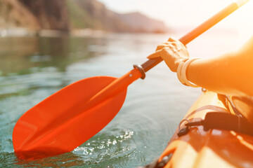 Kayak paddle sea vacation. Person paddles with orange paddle oar on kayak in sea. Leisure active...