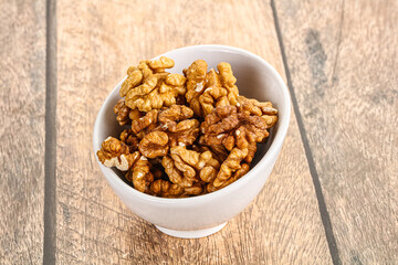 Cracked unshelled walnut in the bowl