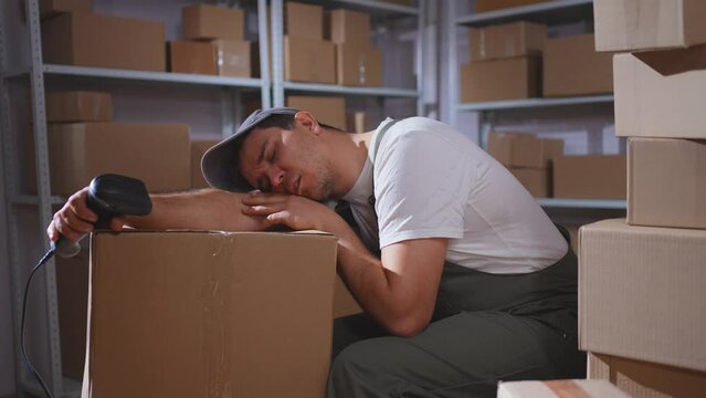 A male mover,a box warehouse worker sleeps at his workplace
