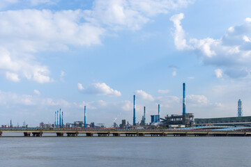 A factory with chimneys towering by the seaside with tall chimneys