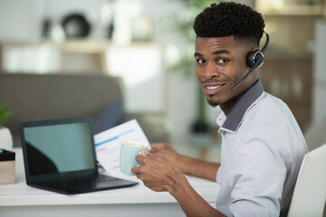 handsome man wearing a headset calling customer at work