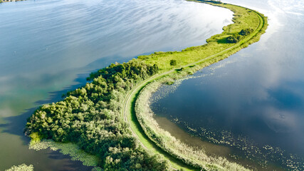 Aerial drone view of path on dam in polder water from above, landscape and nature of North Holland,...