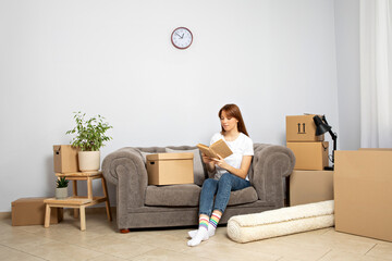 The concept of moving, a girl with boxes in an apartment.
