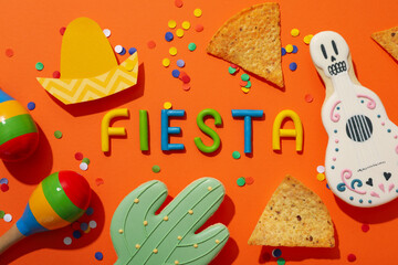 Naklejka premium The inscription Fiesta with decorations on an orange background