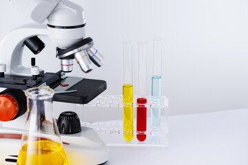 Microscope and laboratory glassware containing chemical liquid for research and analysing. Laboratory equipment for research and student study. - 775619541