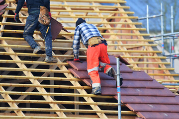 ouvrier couvreur sur un toit d'habitation  - obrazy, fototapety, plakaty