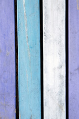 Background from wooden boards in pastel colors. Close-up of wooden boards painted in white, blue, and purple colors. Color background with space for text. Vintage board, multi-colored wood background