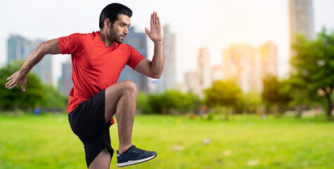 Athletic and sporty man running posture at outdoor green city park exercise session for fit...