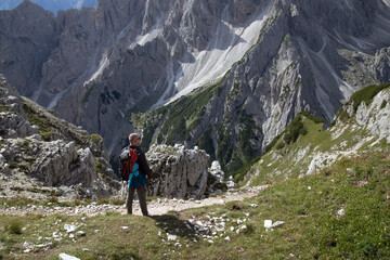 Stunning view of a tourist on the top of a hill enjoying the view of the Cadini di Misurina - 775641993