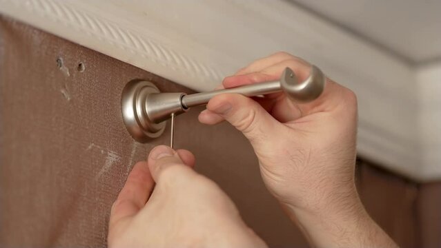 Brass curtain hardware and accessories. Man install mechanism in wall to hang cornice in old apartment. Close up. Concept cheap home renovation in old room