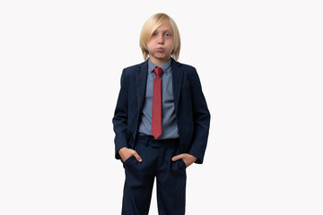 Portrait of a boy in a business suit with puffed out cheeks, holds hands in pockets. Isolated on white background.