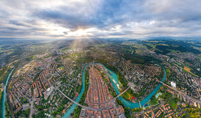 Bern, Switzerland. Panorama of the city in cloudy weather. Sun rays. Summer morning. Aerial view - obrazy, fototapety, plakaty