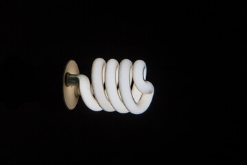 fluorescent power saving lightbulb black backgrond shot, photo is selective focus with shallow depth of field, taken at Cairo Egypt