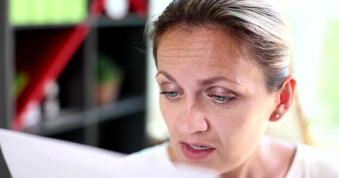Portrait of confused business woman squinting, seeing better. Girl is trying to read paper document and difficulty seeing text due to problems and vision problems