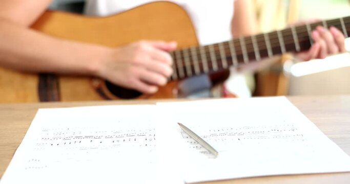 Man is playing guitar with musical chords and musical notes. Guitar lessons and music lessons