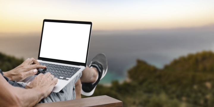 a man works in nature, sitting in a chair with a laptop