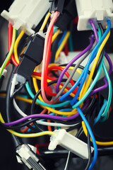 The mess of various tangled wires and connectors. Colorful cables of electronic device with bad...