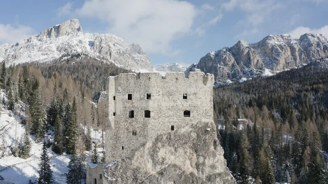 Medieval ruins of castle Andraz with natures Dolomite mountains backdrop AERIAL
