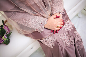 Bride hand with beautiful ring on wedding dress.