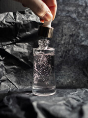 Jar with collagen, peptides, glycerin and antioxidants on a black background. The concept of...