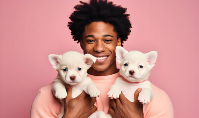 Close up shot of pleased handsome man with Afro hair holds two puppies, spends leisure time with loyal animal friends
