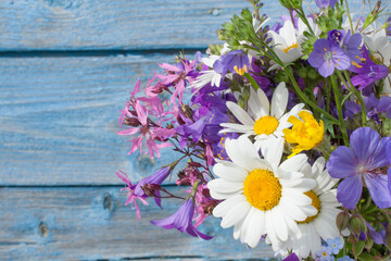 Bouquet of wildflowers on a background of a blue wooden wall